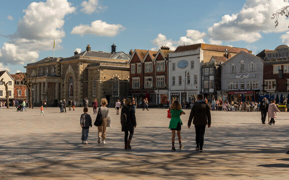 Salisbury, Wiltshire, England, UK. 2023. People walk on Market Place in the city centre surrounded with historic buildings, The Guildhall, shops and offices.