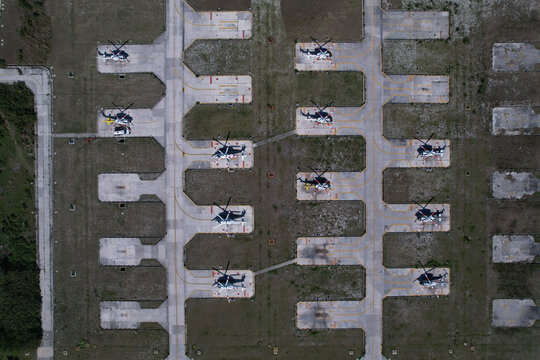 Estacionamiento de helic&oacute;pteros con algunos estacionados dentro de un aeropuerto, vista a&eacute;rea de drone sobre helic&oacute;pteros