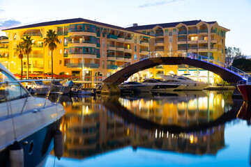 Twilight in Frejus, South of France. View of Buildings and bridge across Reyran River illuminated by city lights.