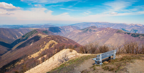 A wooden bench to admire the Ligurian Apennines viewpoint, from the top of Monte Antola  it is a small peak on the border between Piedmont and Liguria regions (Northern Italy). © stefanopez