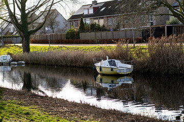 A house with a canal, tree, and boat view