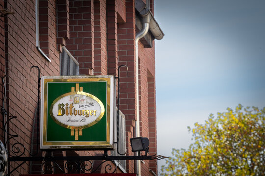 TROISDORF, GERMANY - NOVEMBER 13, 2022: Selective blur on a Bitburger logo on their main retailer for Troisdorf. Bitburger is a german beer brand, one of the biggest producer of germany.