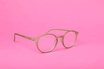 Glasses with corrective lenses on bright pink background