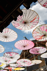 Close up on the paper umbrellas as a roof against the sun and the blue sky behind it, Lijiang Old Town