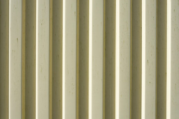 An abstract image of corrugated yellow metal on a shipping container.