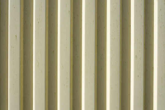 An abstract image of corrugated yellow metal on a shipping container.