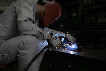 火花が散る溶接をする工場の作業員