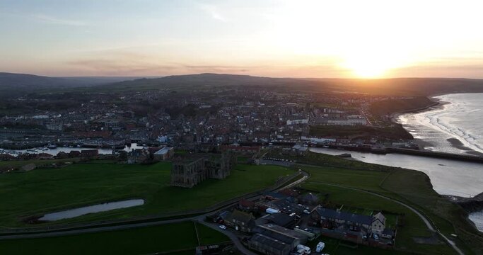 Whitby headland at sunset, dark shadows, pier abbey and town - aerial footage prores 4k Clip 4