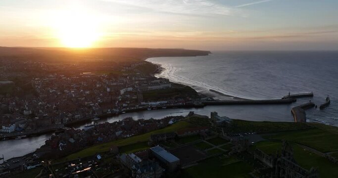 Whitby headland at sunset, dark shadows, pier abbey and town - aerial footage prores 4k Clip 3