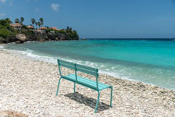 Blue chair on a beach with coral stones on the shore on the island of Curacao. Netherlands Antilles.