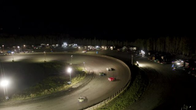 Drone footage of race cars drifting at a night time speedway in Kenai Alaska.