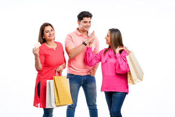 Indian people holding shopping bags and showing bank card on white background.