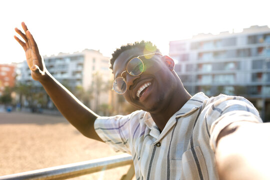 African American man taking selfie outdoors. Happy, African american Black male looking at camera waving hello.