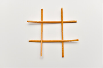 Four pretzel sticks on white background. Tic tac toe