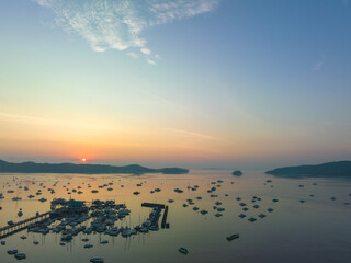 aerial view beautiful sunrise cloud above Chalong pier..Sunrise with sweet yellow color light rays and other atmospheric effects..colorful reflection of sunrise in the sea background.