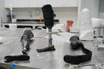 Orthopedic technician making prosthetic leg for disabilities people in workshop. - obrazy, fototapety, plakaty
