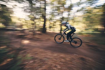 Crédence de cuisine en verre imprimé Montagnes Bicycle, mountain bike and man cycling in the forest or woods fast, speed and adrenaline with motion blur. Extreme sports, actions and rider cycling for exercise, fitness and workout in nature