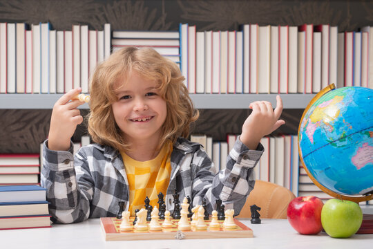 Clever child thinking about chess. Portrait of clever kid with chessboard.