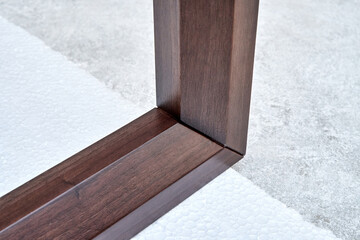 Wooden frame of bedside table made of solid walnut in workshop. Joinery angular joint of planks on...