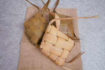 Ketupat (Rice Dumplings) On Silver and white Background. Ketupat is a natural rice shell made from young coconut leaves to cook rice during Eid, Idul Fitri