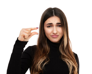 Portrait of sed twenty year old girl shapes little gesture with hand demonstrates something very...