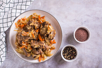 Stewed oxtail with carrots and onions on a plate on the table top view