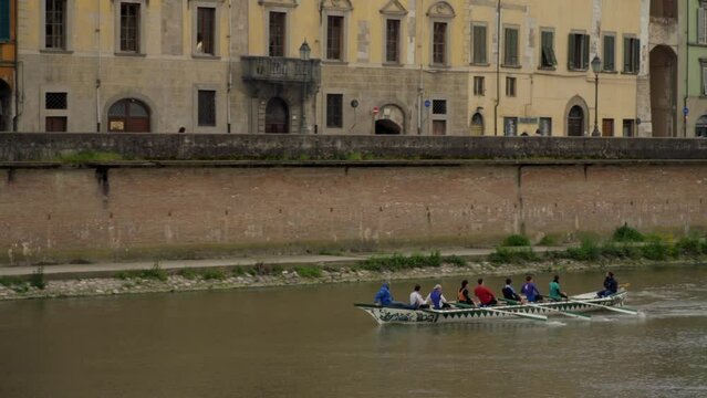 Boat rowing down the Arno river in Pisa, Italy