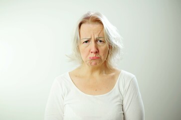Pretty upset woman Adult woman with white hair is offended She shows her tongue expressively Her...