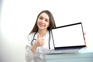 Female doctor in white coat with stethoscope working and typing on laptop computer keyboard at medical office in Hospital. Online medical working, telehealth, telemedicine concept. High quality photo