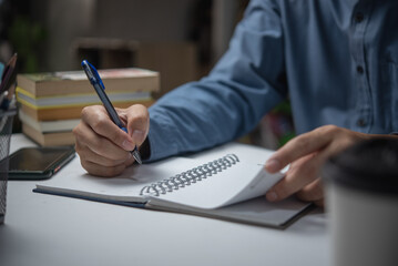 Businessperson hands with pen writing on notebook in the office.learning, education and work.writes...