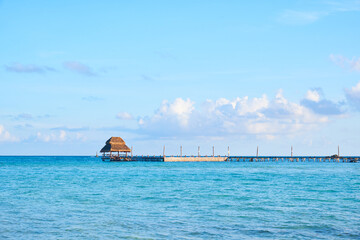 rustic pier on north beach, isla mujeres. turquoise blue sea of the mexican caribbean and a sky full of clouds. midday