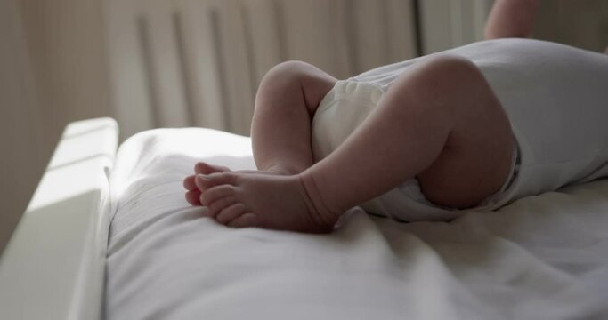 New born baby boy lies on the back on bedsheet