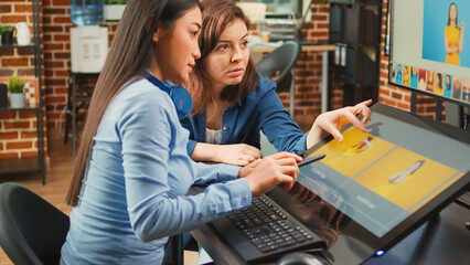 Team of photographers working on photography edit with touchscreen monitor, using stylus on graphic...