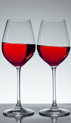 two glasses of wine on gray background