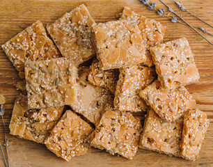 Multigrain cereal crunchy squares bars with pumpkin seeds on wooden background
