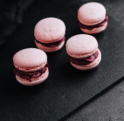macarons with chocolate filling on black stone