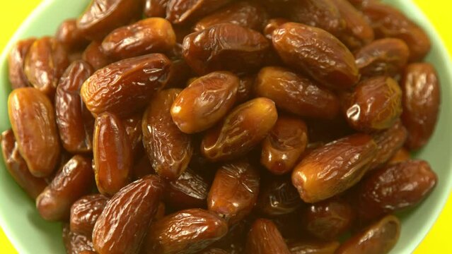 Dates. Dried date palm fruits. Healthy sweet snack food bowl. Pile of tasty dry dattes in plate. Date harvest symbolizing Ramadan.