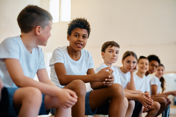 Group of happy elementary students having PE class at school and looking at camera.