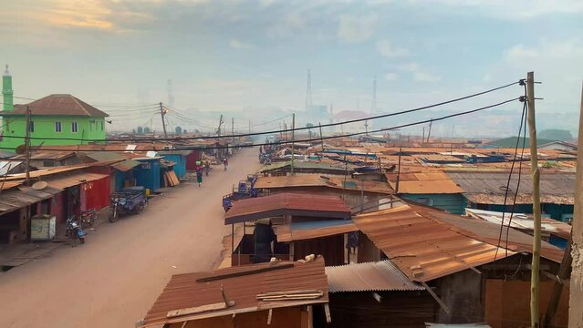 Areal view of a morning in the slums in Ghana Africa with rusted iron sheets and wooden houses population starting their day in the streets