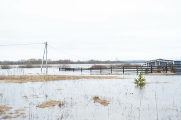 Spring flood in rural areas - flooding of the river, flooding of house territories behind the fence. The elements after the melting of snow and heavy rains