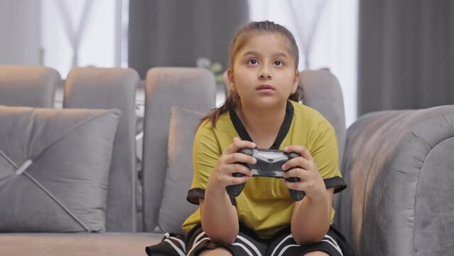 Indian girl playing video games using controller