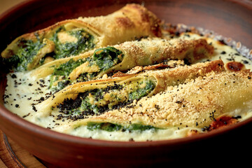 Pancakes with spinach, nuts in a creamy sauce. Ukrainian cuisine Blini or mlynets.