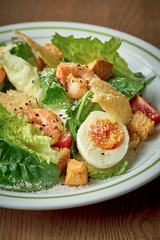 Salad with vegetables, tuna and boiled egg. Nicoise salad. Wooden background