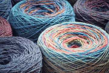 Round skeins of organic multi-coloured lambswool yarn.
