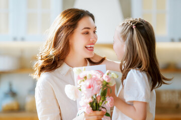 Fototapeta na wymiar Daughter giving mother bouquet of flowers.