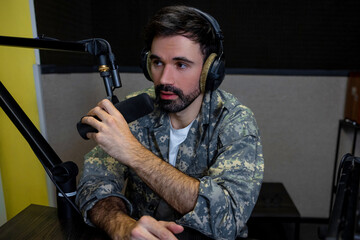 Dark-haired young man with a microphone in hand