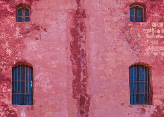 Fototapeta na wymiar Red wall with small windows of Saint Agathas Tower, Malta