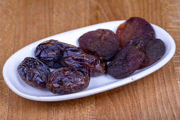 Dried apricots and date furit. Naturally Dried apricots and dates in a ceramic bowl. Close up