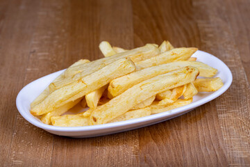Fried potatoes or potato chips. Hand peeled french fries in a ceramic bowl. close up