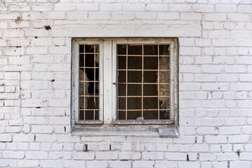 Fototapeta na wymiar brick wall of a house with a window and a lattice in Ukraine